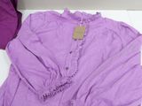 purple shirt with ruffles on the collar and long sleeves