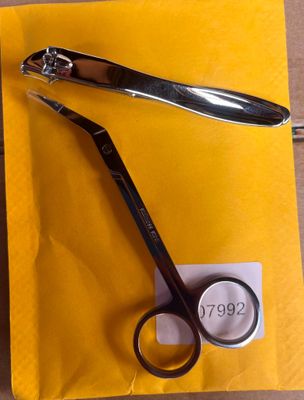 a pair of scissors sitting on top of a yellow envelope