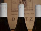 three bottles of wine sitting on a table next to a book