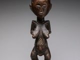 a wooden statue of a woman with a hat on her head