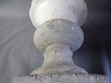 a white vase sitting on top of a cement base
