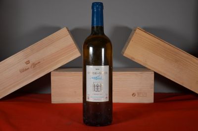 a bottle of wine sitting on a table next to two wooden boxes