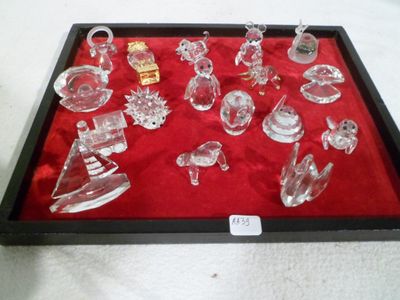 de nombreuses figurines en verre exposées dans une vitrine
