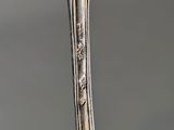 a close up of a spoon on a table with a gray background