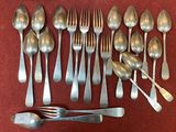 a lot of spoons and forks laid out on a table