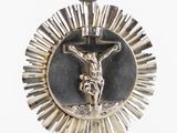silver metal crucifix with sunburst and cross on it