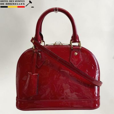 a close up of a red handbag on a white background