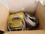une boîte en carton remplie d'objets divers et une main tenant un téléphone