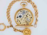 a gold pocket watch with a chain around it