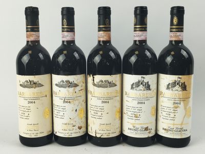 quatre bouteilles de vin sont alignées sur une surface blanche
