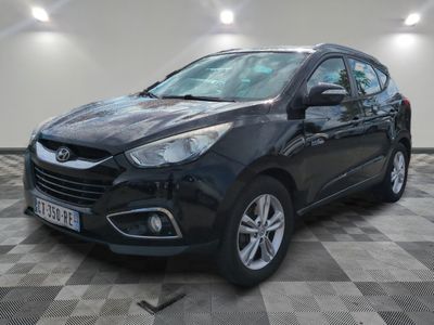 la voiture noire est garée sur un sol en damier dans le garage