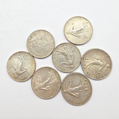 six pièces de monnaie britanniques différentes empilées les unes sur les autres sur une surface blanche