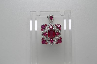 un gros plan d'un pendentif en diamants rouges et blancs exposé