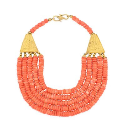 un collier composé de perles de corail et de touches dorées sur fond blanc