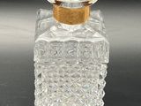 an image of a clear glass bottle with a gold lid
