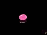 a close up of a pink diamond on a black surface