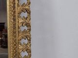 an ornate gold framed mirror on a white wall in a living room
