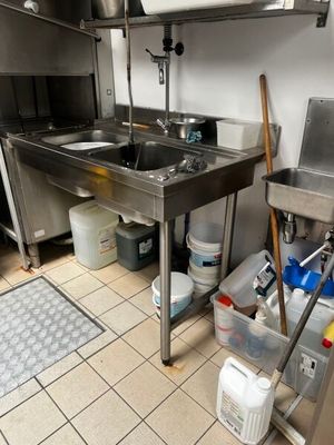 une cuisine équipée d'un évier, d'une cuisinière et d'autres éléments