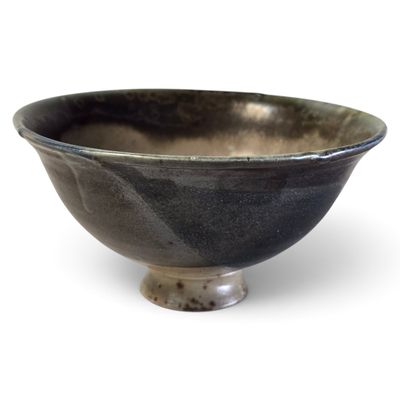 un bol noir posé sur une table blanche