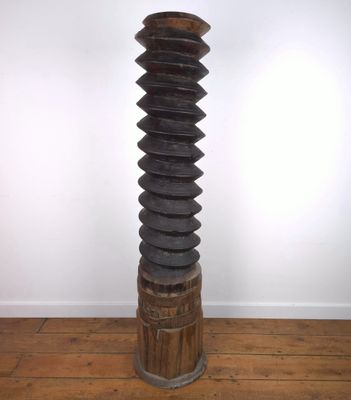 une photo représentant une grande sculpture en bois posée sur un parquet en bois dur