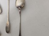 five spoons and two spoons sitting on a table