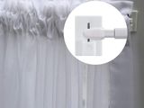 une photo d'un rideau blanc suspendu à une fenêtre