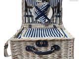 a wicker picnic basket with a plate and fork and knife