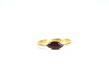 une image représentant une bague en or sertie d'une pierre rouge