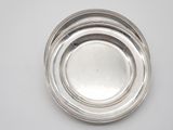 three silver plates on top of each other on a white surface