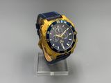 blue and gold watch sitting on a clear stand on a white surface