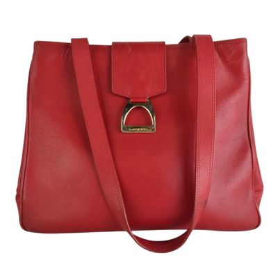 a red leather handbag with a metal ring on the front