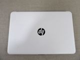 the laptop is white and has a black hp logo on it