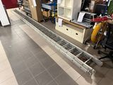 a long metal conveyor belt in the middle of a room