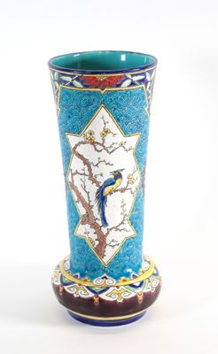 un vase bleu orné d'un oiseau, posé sur une table