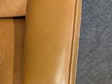 a brown leather chair with a brown seat and arm rest