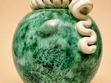 a picture of a green vase with white spirals on it
