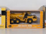 three boxes of toy construction vehicles sitting on a table