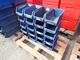 de nombreux bacs bleus empilés sur une palette dans un entrepôt