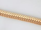 an image of a gold bracelet on a white surface