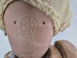 a small doll with a hat on it ' s head