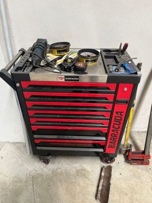 une boîte à outils posée dans un garage, avec des outils dessus
