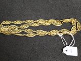 a close up of a gold chain with a tag on it