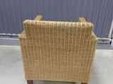 a wicker chair that is sitting in front of a wall