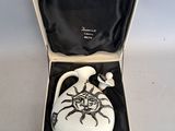 a white vase in a box with a black lid