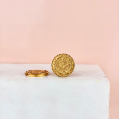 a gold coin sitting on top of a white block