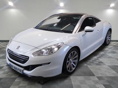 La voiture blanche est garée sur le sol à damier de la pièce.