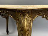 une table dorée avec un plateau en marbre sur fond gris