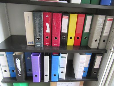de nombreux classeurs sur une étagère dans une pièce