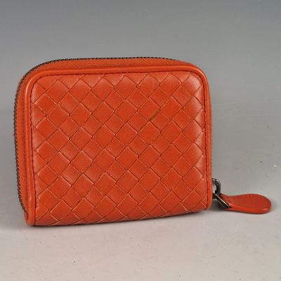 an orange leather wallet with a zipper on the front and a zipper on the back