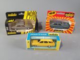 three small toy cars are sitting on a table next to each other